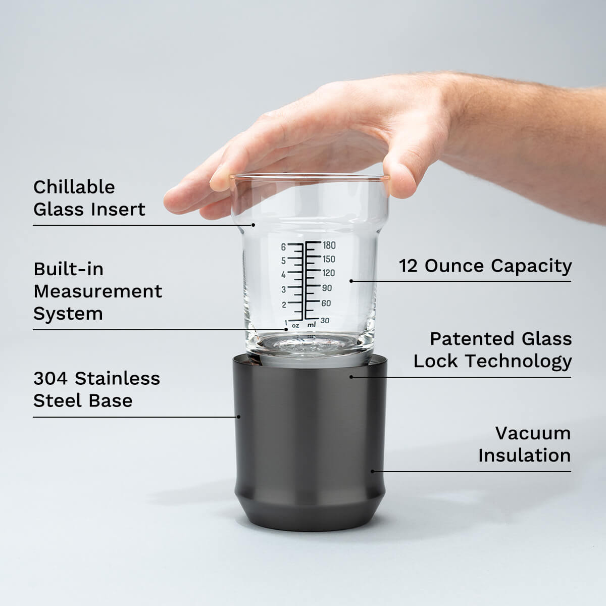 Hand holding the Elevated Craft Hybrid cocktail glass insert above the gunmetal black finish steel base