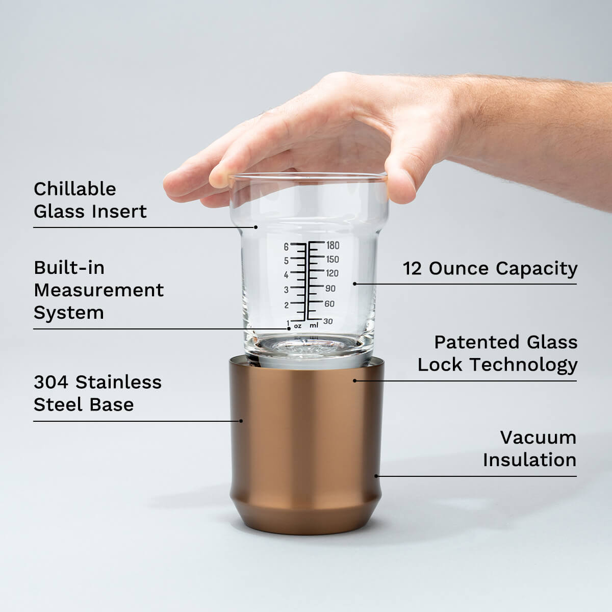 Hand holding an Elevated Craft Hybrid cocktail glass insert above the stainless steel base in brushed copper finish