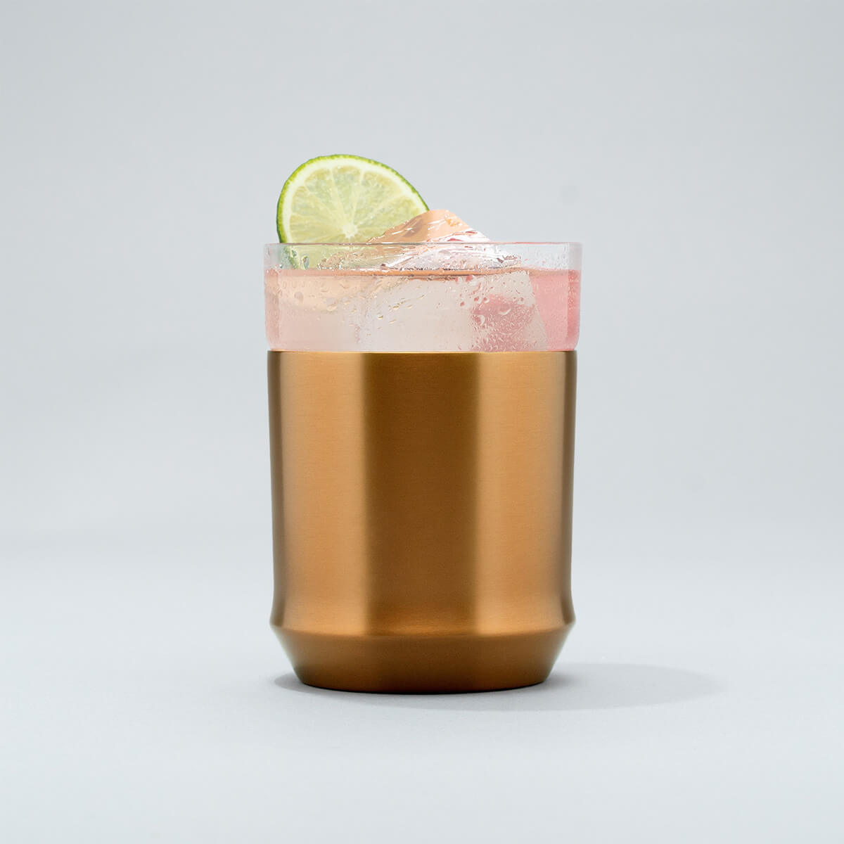 The Elevated Craft Hybrid Cocktail Glass in brushed copper finish filled with bright pink cocktail garnished with a lime wheel
