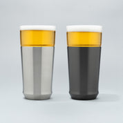 The Elevated Craft Hybrid Pint Glass in brushed stainless finish next to a hybrid pint glass in gunmetal black finish