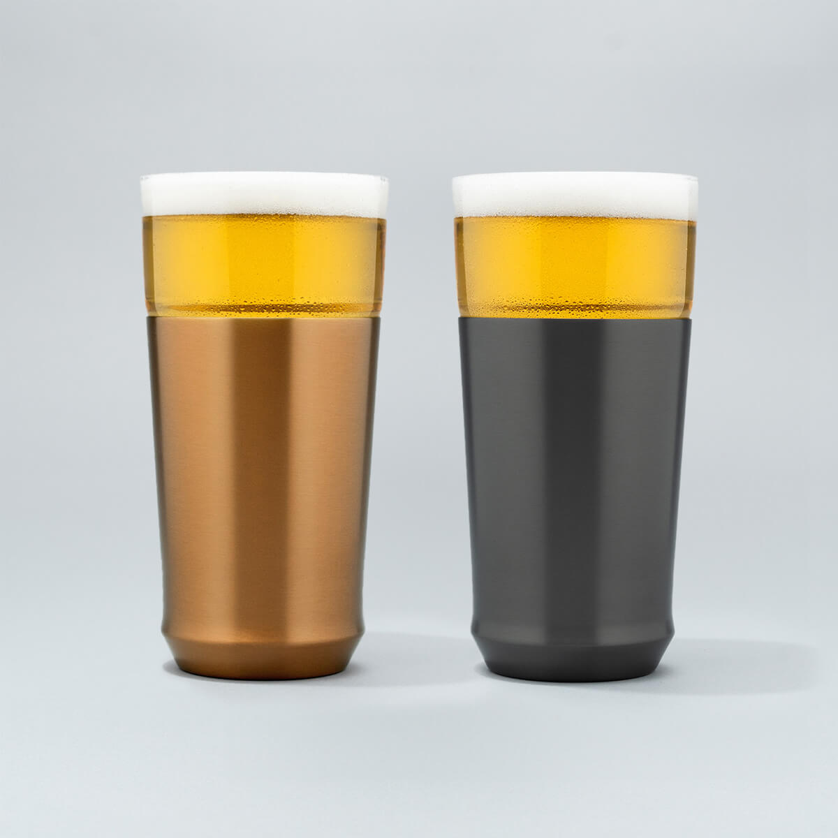 The Elevated Craft Hybrid Pint Glass in brushed copper finish next to a hybrid pint glass in gunmetal black finish