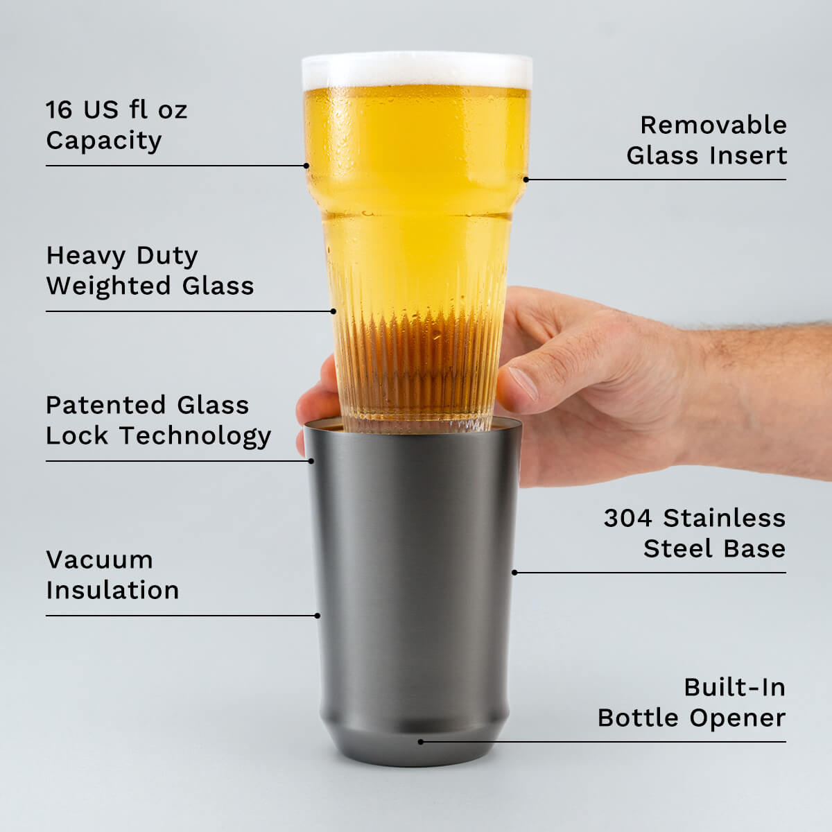 Hand holding glass insert of Elevated Craft Gunmetal Black Hybrid Pint Glass above the steel base with feature callouts