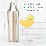 Stainless Steel Elevated Craft Hybrid Cocktail Shaker next to yellow cocktail with lime on top