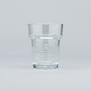 Clear glass tumbler with engraved design on a light gray background