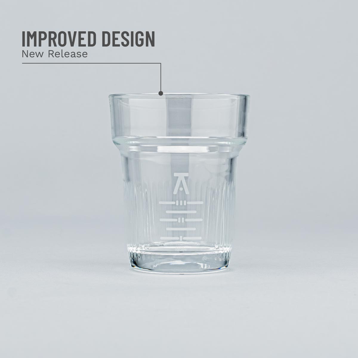 Clear glass tumbler with branding on a light gray background
