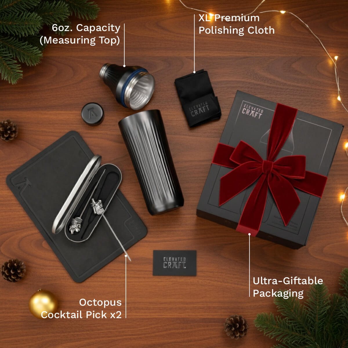 Gifting set with cocktail pick, measuring top, and polishing cloth on a wooden surface.