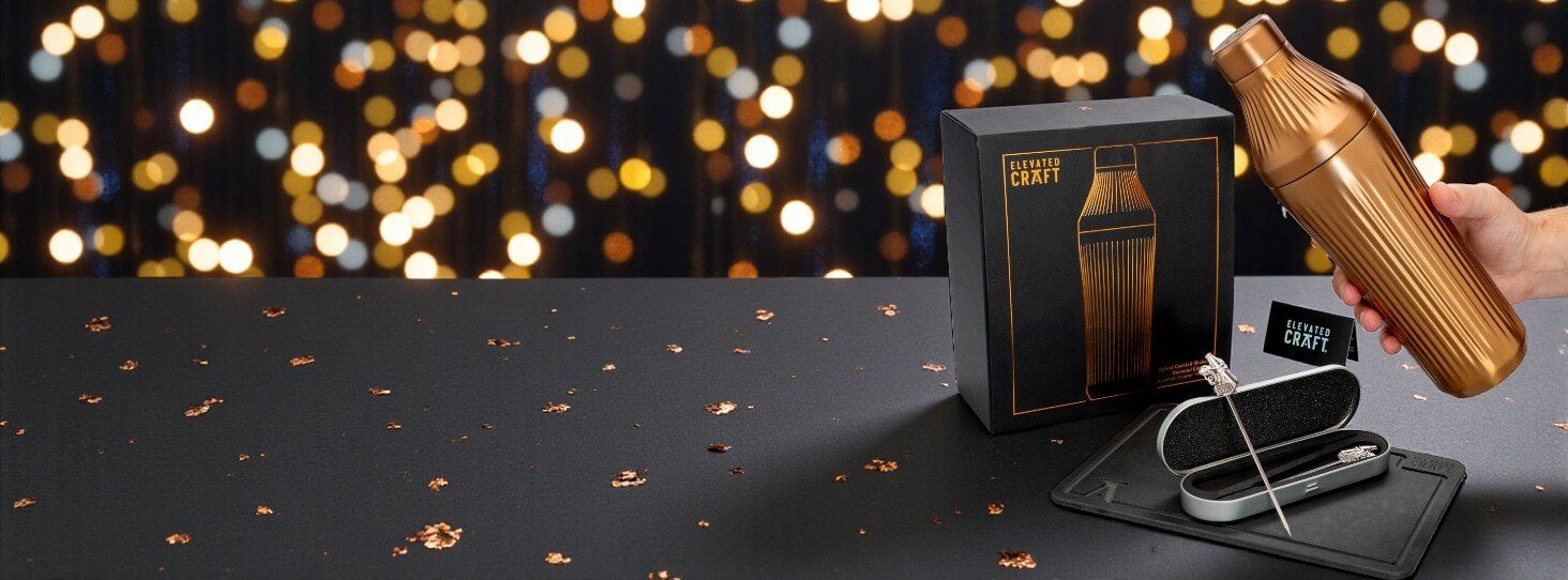 Gold and black CRAFT product with packaging on a dark surface with blurred lights in the background