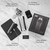 Cocktail shaker set with accessories on a light wooden surface