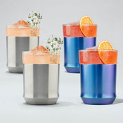 Two stainless steel and two blue tumblers with orange slices and garnishes on a light gray background