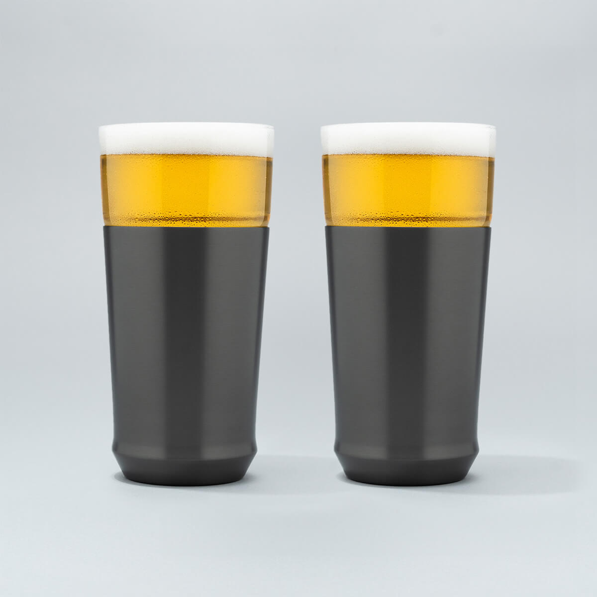 Two Elevated Craft hybrid pint glasses in gunmetal black finish full of cold beer