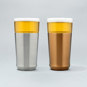 The Elevated Craft Hybrid Pint Glass in brushed stainless finish next to a hybrid pint glass in brushed copper finish