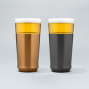 The Elevated Craft Hybrid Pint Glass in brushed copper finish next to a hybrid pint glass in gunmetal black finish