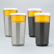 Two Elevated Craft brushed stainless hybrid pint glasses filled with cold beer next to two gunmetal black hybrid pint glasses filled with cold beer