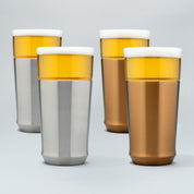 Two Elevated Craft brushed stainless hybrid pint glasses filled with cold beer next to two brushed copper hybrid pint glasses filled with cold beer
