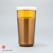 The Elevated Craft Hybrid Pint Glass in brushed copper finish filled with cold beer to the top of the rim with the 2024 red dot design award logo overlaid in the bottom left corner
