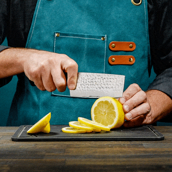 Person using a nakiri knife on a wooden surface cutting a lemon