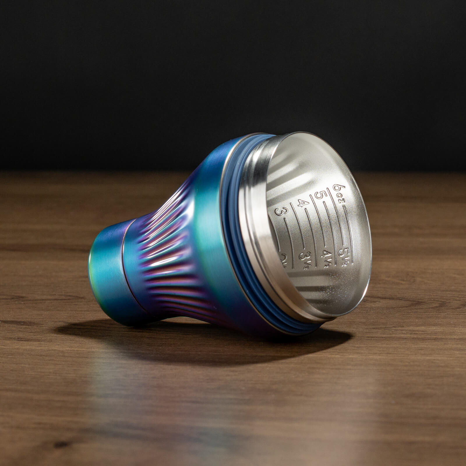 Metallic Iridescent  and silver container on a wooden surface with a dark background