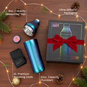 Elevated Craft product with blue tumbler, polishing cloth, and gift box on a wooden surface with decorative lights and pine branches.