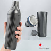Hand holding a Gunmetal Black Diamond Edition Hybrid Cocktail Shaker with another image of the shaker taken apart to show the parts separate on gray background with RedDot Winner 2025 logo overlay