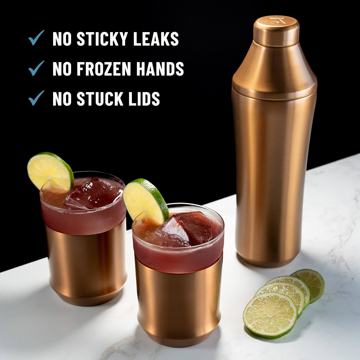 Elevated Craft Brushed Copper Hybrid Cocktail Shaker next to dark red cocktail in the Hybrid Cocktail Glass topped with lime slices with callouts "No sticky leaks, no frozen hands, no stuck lids"