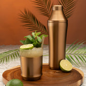 Elevated Craft Brushed Stainless Hybrid Cocktail Glass filled with Mai Tai cocktail topped with spent lime and mint next to the Hybrid Cocktail Shaker