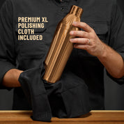 Man in dark grey button down shirt holding the Brushed Stainless Elevated Craft Diamond Edition Hybrid Cocktail Shaker being polished with a Premium XL Polishing Cloth with callout saying Polishing Cloth is included