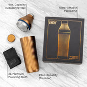Cocktail shaker set with packaging, measuring top, tumbler, and polishing cloth on a white background.