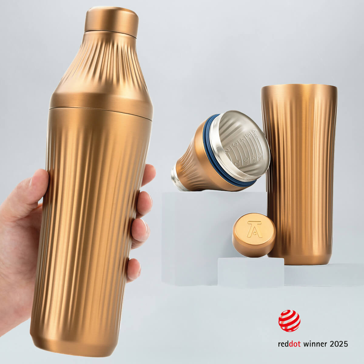 Hand holding a Brushed Copper Diamond Edition Hybrid Cocktail Shaker with another image of the shaker taken apart to show the parts separate on gray background with RedDot Winner 2025 logo overlay
