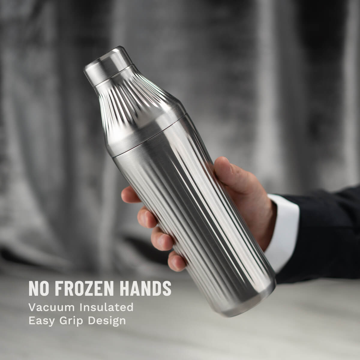 Hand holding Stainless Steel Elevated Craft Diamond Edition Hybrid Cocktail Shaker with suit arm