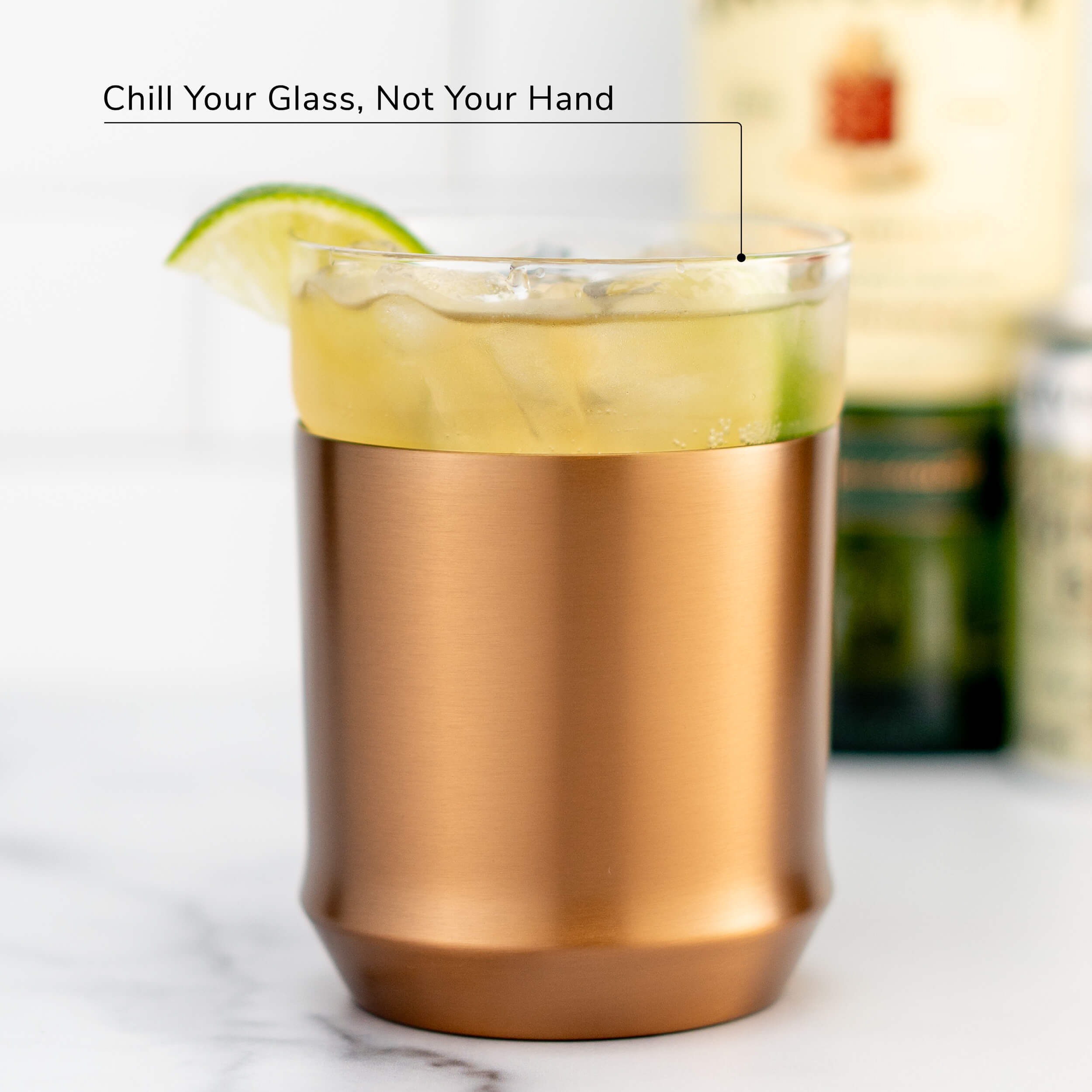 Hybrid Cocktail Glass in brushed copper finish filled with bright yellow cocktail garnished with lime wheel garnish