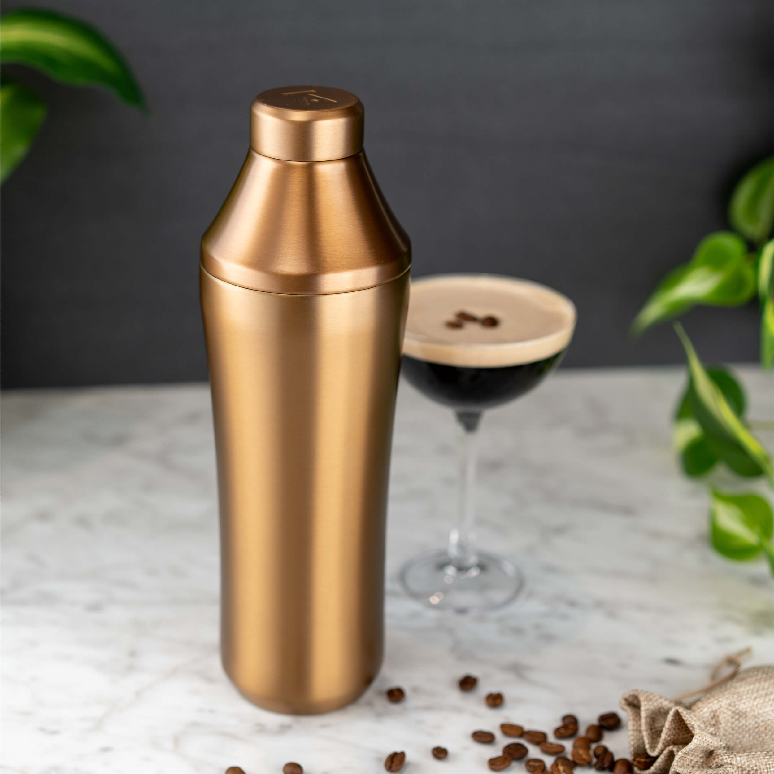 Brushed Copper Elevated Craft Hybrid Cocktail Shaker next to espresso martini with foam and espresso beans on top