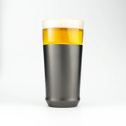 The Elevated Craft Hybrid Pint Glass in gunmetal black finish filled with cold beer to the top of the rim