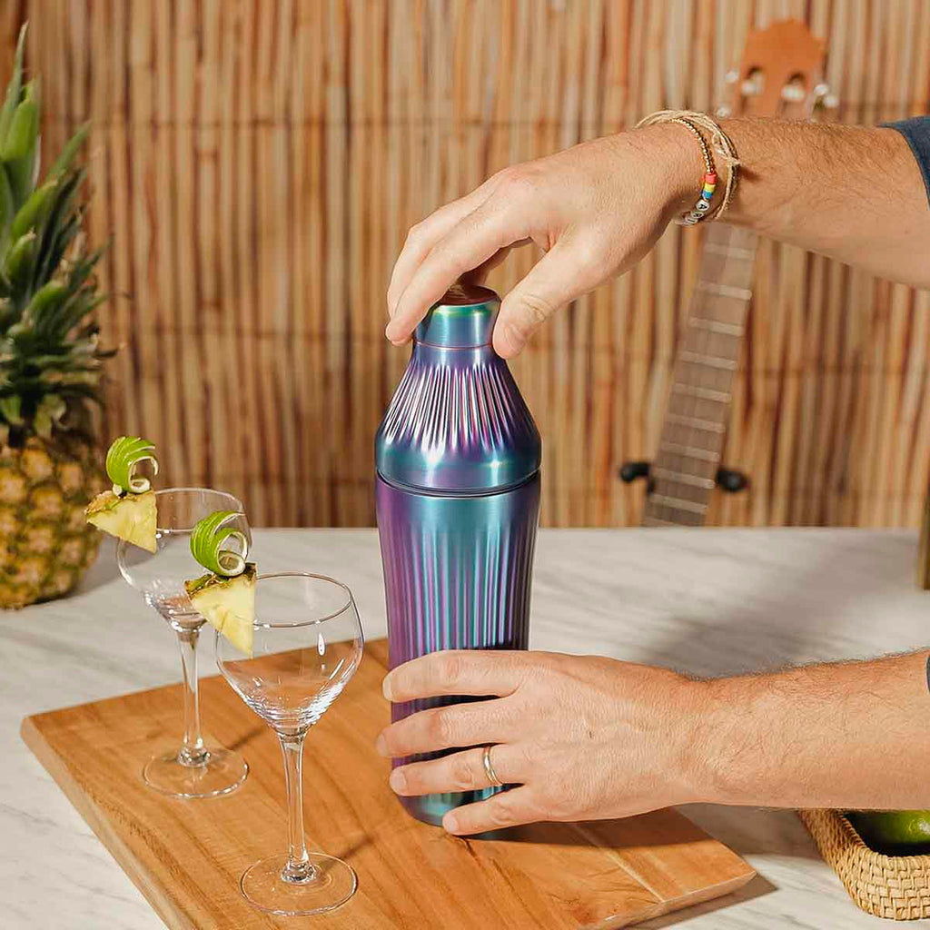 Video of Elevated Craft brushed aurora diamond edition hybrid cocktail shaker making a drink in a tiki beach environment. 